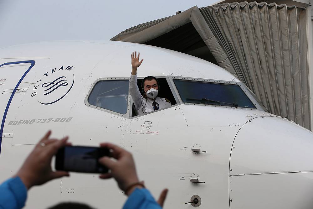 A pilot leans out to wave goodbye before the China Eastern airlines flight, the first domestic flight from Wuhan to leave the capital of Hubei province, China April 8, 2020. u00e2u20acu201d China Daily pic via Reuters
