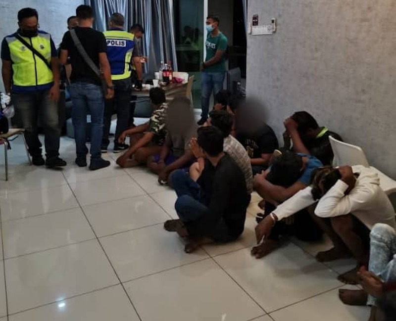 A group of men caught by policemen after organising a private party during the movement control order at Jalan Pangkor April 15, 2020. u00e2u20acu201d Picture by Royal Malaysia Police 
