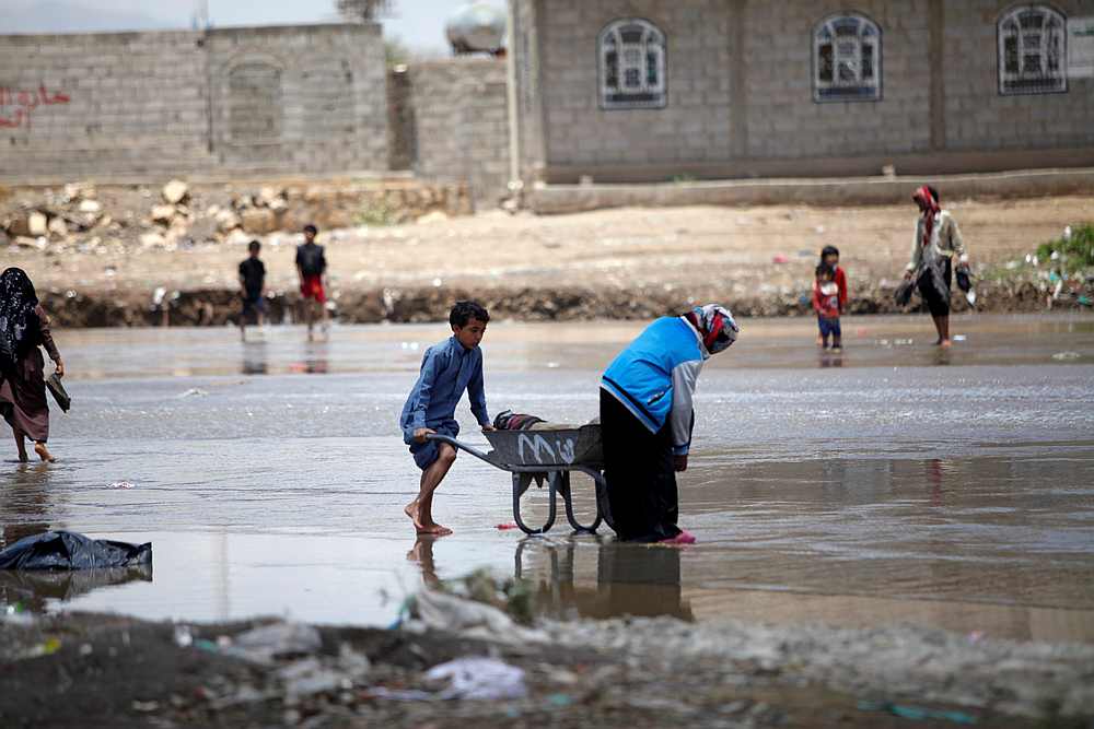 People carry their belongings washed by rain water after the heavy rain in Sanaa, Yemen April 17, 2020. The OIC is keen on a ceasefire in conflict areas to allow delivery of aid. u00e2u20acu201d Reuters pic