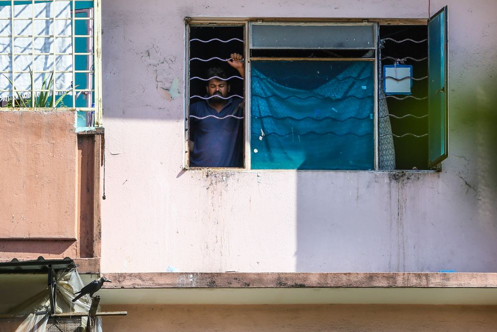 A man looks out the window of his flat unit in Selangor Mansion, Kuala Lumpur April 11, 2020. u00e2u20acu201d Picture by Yusof Mat Isa