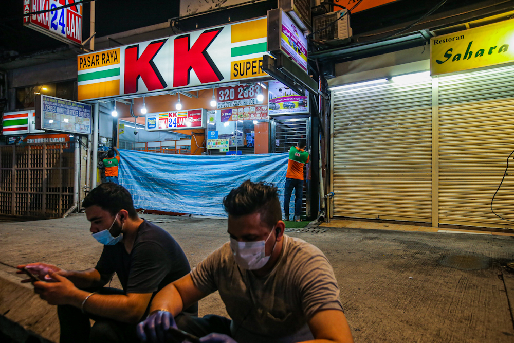 A KK supermarket employee prepares to close the store following the second phase of the MCO, which sees shops limiting their operating hours April 1, 2020. u00e2u20acu201d Picture by Hari Anggara