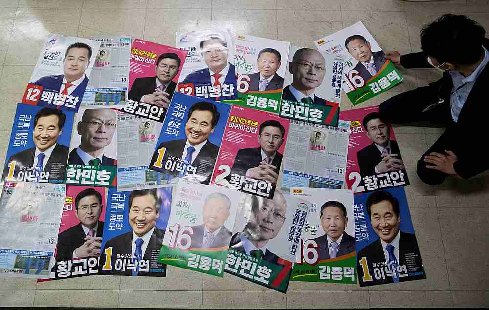 An official from the National Election Commission checks posters for candidates of upcoming parliamentary election in Seoul, South Korea April 1, 2020. u00e2u20acu201d Yonhap pic via Reuters