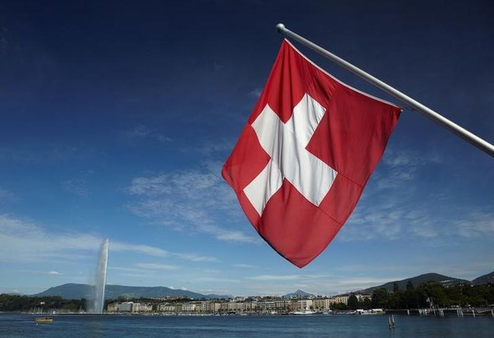 A Swiss flag is pictured next to the Jet du00e2u20acu2122Eau (water fountain), and the Lake Leman from the St-Pierre Cathedrale in Geneva, Switzerland, June 5, 2012. u00e2u20acu201d Reuters pic