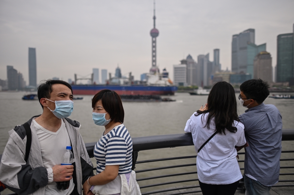 Couples wearing face masks visit the promenade on the Bund along the Huangpu River during a holiday on May Day. u00e2u20acu201d AFP pic