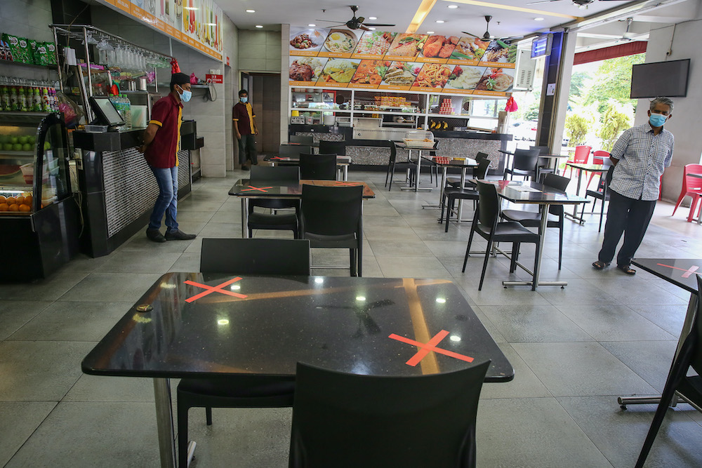 Social distancing marks are placed on each table at Khulafa Restaurant as eateries resume dine-in services starting May 4 in Shah Alam May 2, 2020. u00e2u20acu201d Picture by Yusof Mat Isa