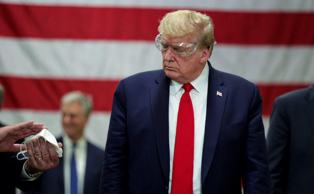 US President Donald Trump looks at a protective mask being shown to him during a tour of Honeywell's facility manufacturing face masks for the coronavirus disease (Covid-19) outbreak in Phoenix, Arizona May 5, 2020. u00e2u20acu201d Reuters pic 