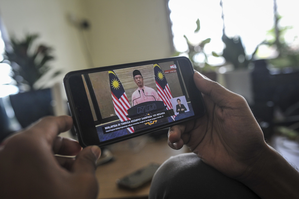 A man watches the live telecast of Prime Minister Tan Sri Muhyiddin Yassinu00e2u20acu2122s special address about the conditional movement control order in Kuala Lumpur May 10, 2020. u00e2u20acu201d Picture Shafwan Zaidon