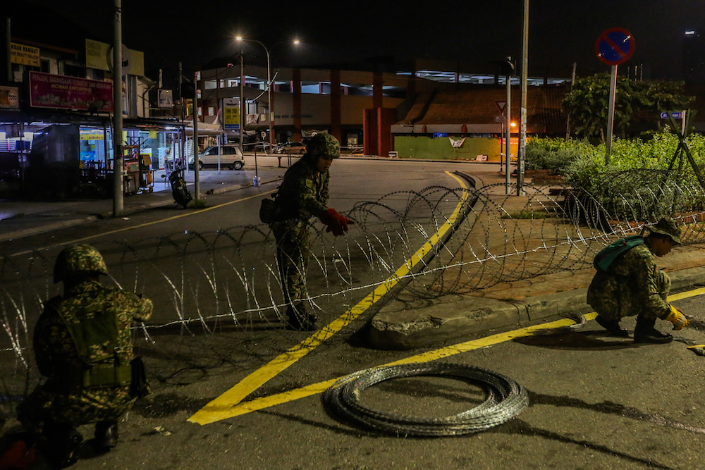 Armed Forces personnel put up barbed wire fencing in Petaling Jaya Old Town that is now under lockdown to curb the spread of Covid-19 May 10, 2020. u00e2u20acu201d Picture by Firdaus Latif