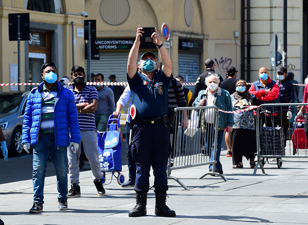 A Police officer wearing a protective face mask takes a photo at Porta Palazzo market in Turin after it reopened with social distancing rules as Italy begins a staged end to a nationwide lockdown in Turin May 4, 2020. u00e2u20acu201d Reuters pic