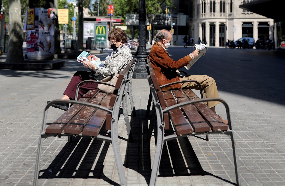Elderly people wearing protective masks read newspapers as they sit on benches, during the hours in which the elderly are allowed to be outdoors, amid the coronavirus disease outbreak, in Barcelona May 4, 2020. u00e2u20acu201d Reuters pic
