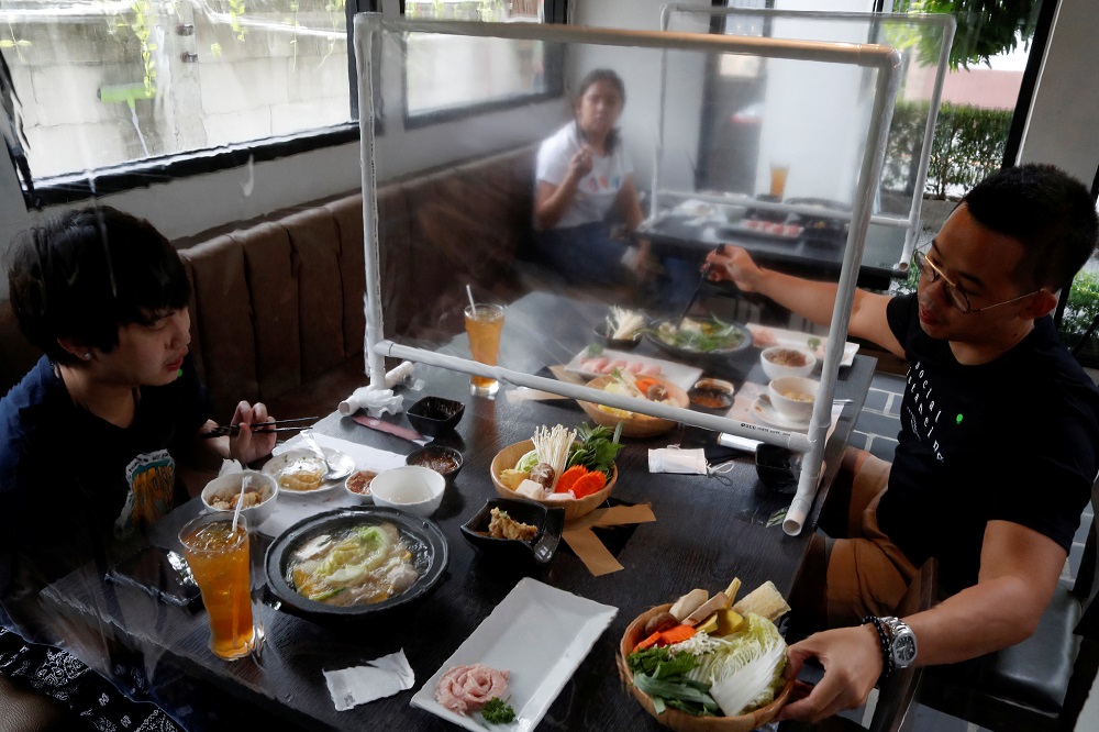 People have lunch in a Taiwanese hot pot style restaurant that reopened after the easing of restrictions with the implementation of a plastic barrier and social distancing measures in Bangkok May 4, 2020. u00e2u20acu201d Reuters pic