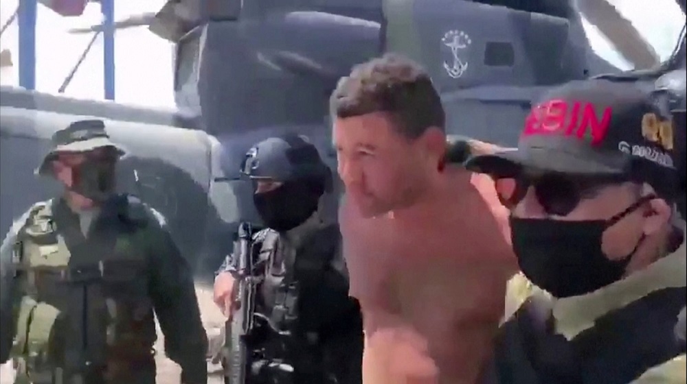 Venezuelan soldiers in balaclavas move a suspect from a helicopter after what Venezuelan authorities described was a u00e2u20acu02dcmercenary incursionu00e2u20acu2122, at an unknown location, May 4, 2020. u00e2u20acu201d Picture courtesy of Venezuelan government TV/Handout via Reuters