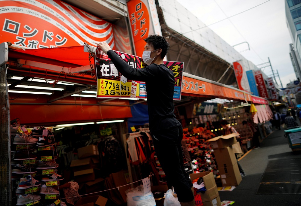 An employee of a shoes shop prepares to reopen their business during the spread of the coronavirus disease in Tokyo May 14, 2020. u00e2u20acu201d Reuters pic