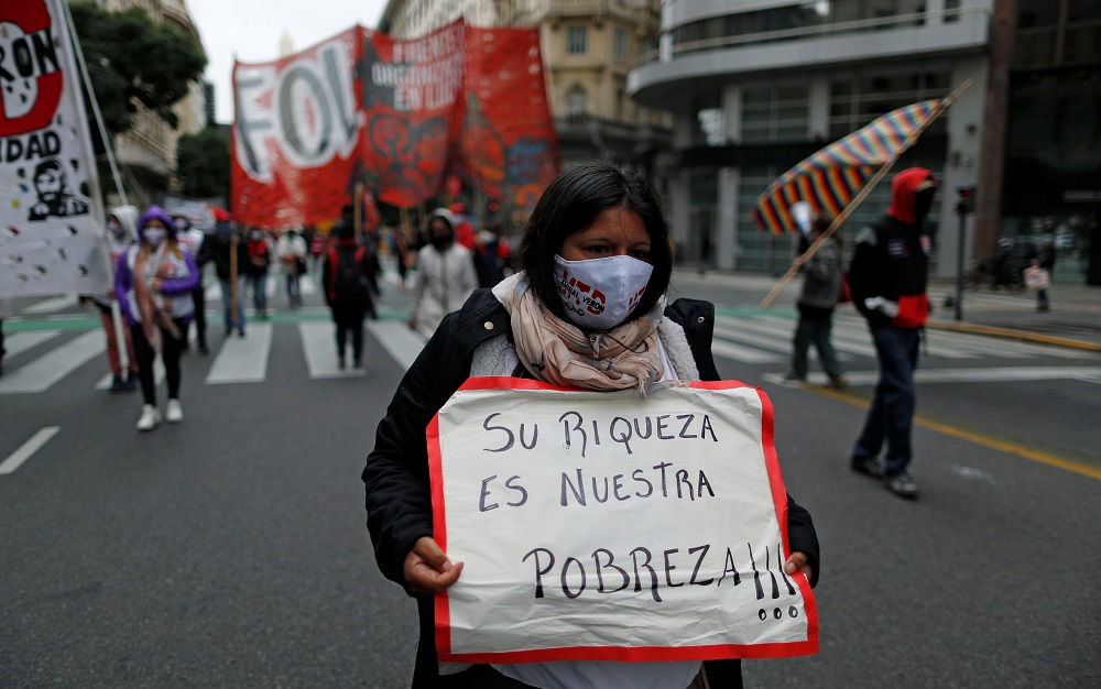 A demonstrator holds a placard that reads u00e2u20acu02dctheir richness is our povertyu00e2u20acu2122, during a protest to demand resources for the vulnerable, amid the Covid-19 lockdown, in Buenos Aires May 21, 2020. u00e2u20acu201d Reuters pic