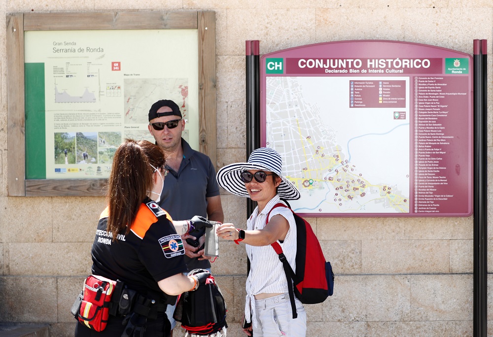 A member of civil protection gives a protective face mask to two touristsamid the outbreak of the coronavirus disease in Ronda, Spain May 21, 2020. u00e2u20acu201d Reuters pic