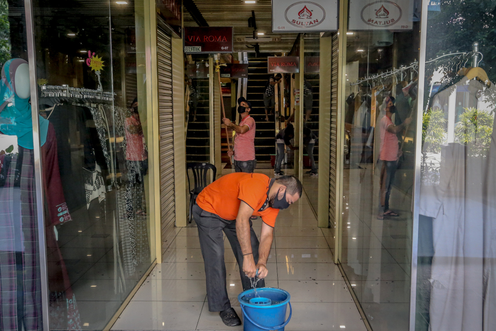 Workers prepare their shops for business during the conditional movement control order (CMCO) at Jalan Tunku Abdul Rahman in Kuala Lumpur May 5, 2020. u00e2u20acu201d Picture by Firdaus Latif