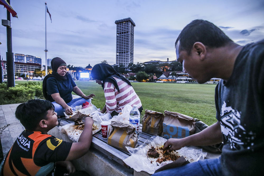 Several people break fast at Dataran Merdeka during the conditional movement control order (CMCO) May 9, 2020. u00e2u20acu201d Picture by Hari Anggara
