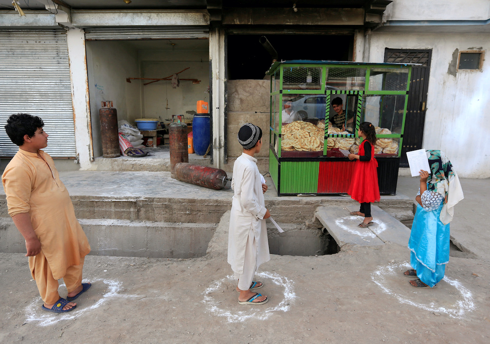 Afghan youths stand on social distancing markers as they buy bread from a bakery, amid the spread of the coronavirus disease (Covid-19), in Jalalabad May 8, 2020. u00e2u20acu201d Reuters picn n