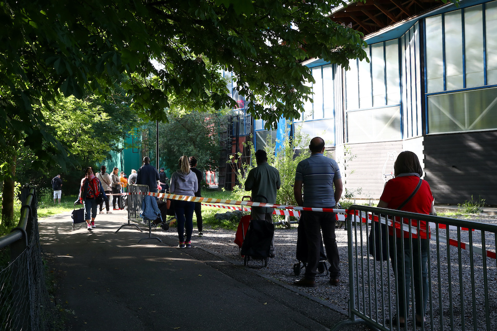People queue to receive bags with food and essential products received from donations at Vernets ice rink in Geneva, following the outbreak of the coronavirus disease (Covid-19), Geneva May 9, 2020. u00e2u20acu201d Reuters picnn