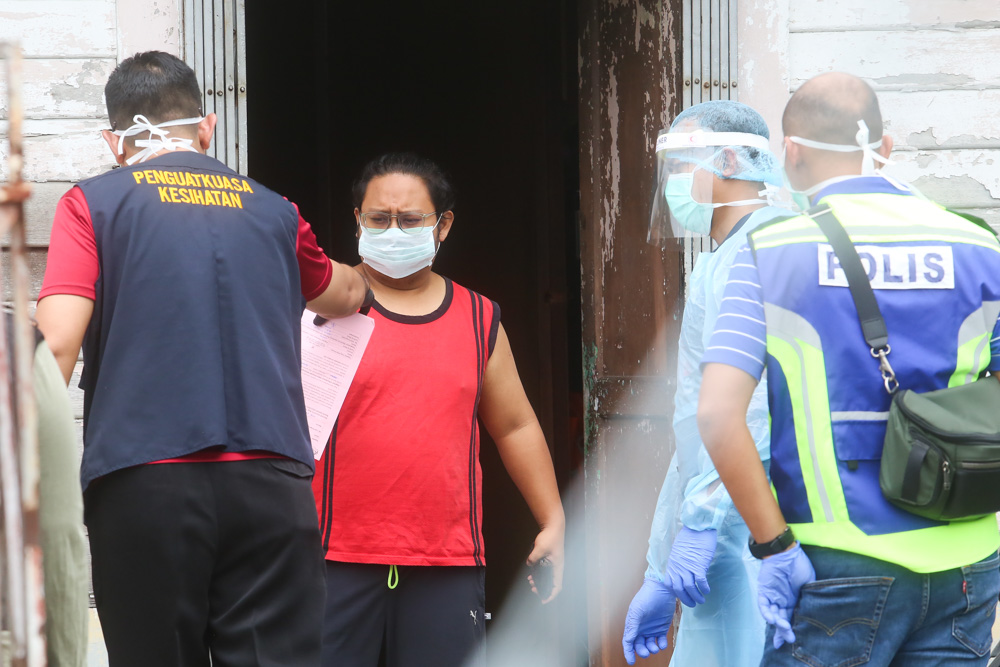 Police officers, health workers and RELA personnel go house to house to check on residents during the Petaling Jaya Old Town enhanced movement control order (EMCO) May 13, 2020. u00e2u20acu201d Picture by Choo Choy May