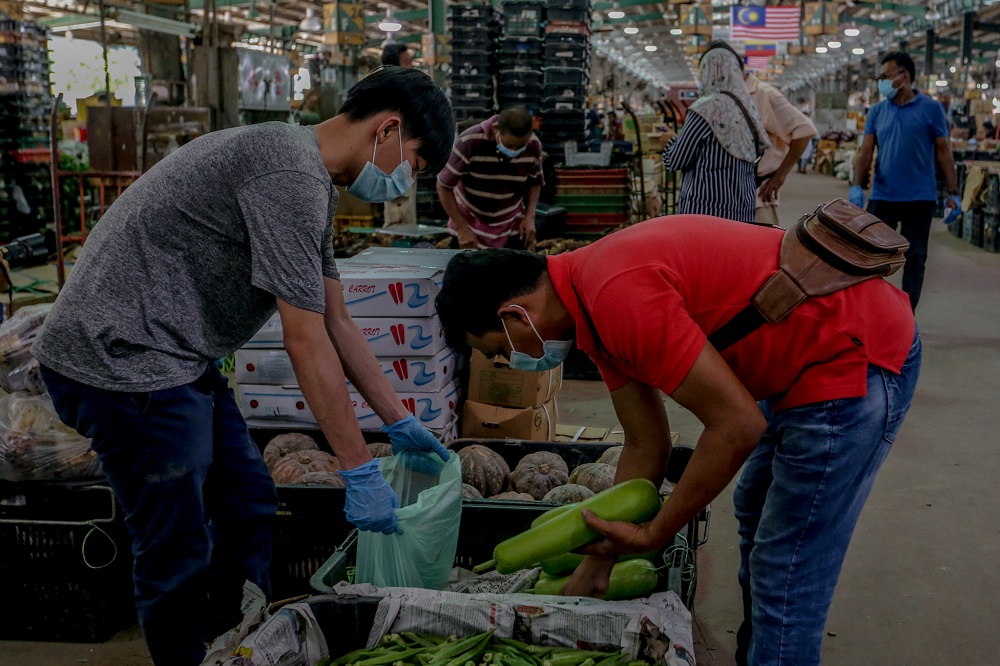 People shop for fresh produce at the Kuala Lumpur wholesale market in Selayang during the enhanced movement control order (EMCO) May 14, 2020. — Picture by Firdaus Latif