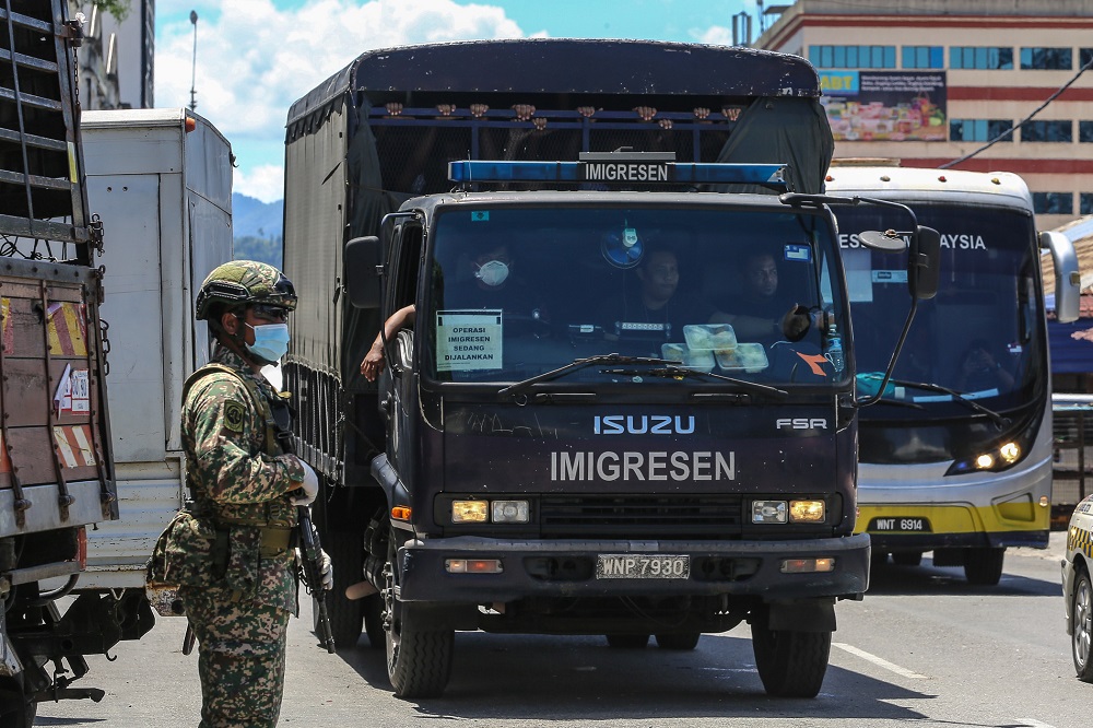 Illegal immigrants are detained by the Immigration Department following raids carried out at Selayang Baru in Kuala Lumpur May 14, 2020. — Picture by Yusof Mat Isa