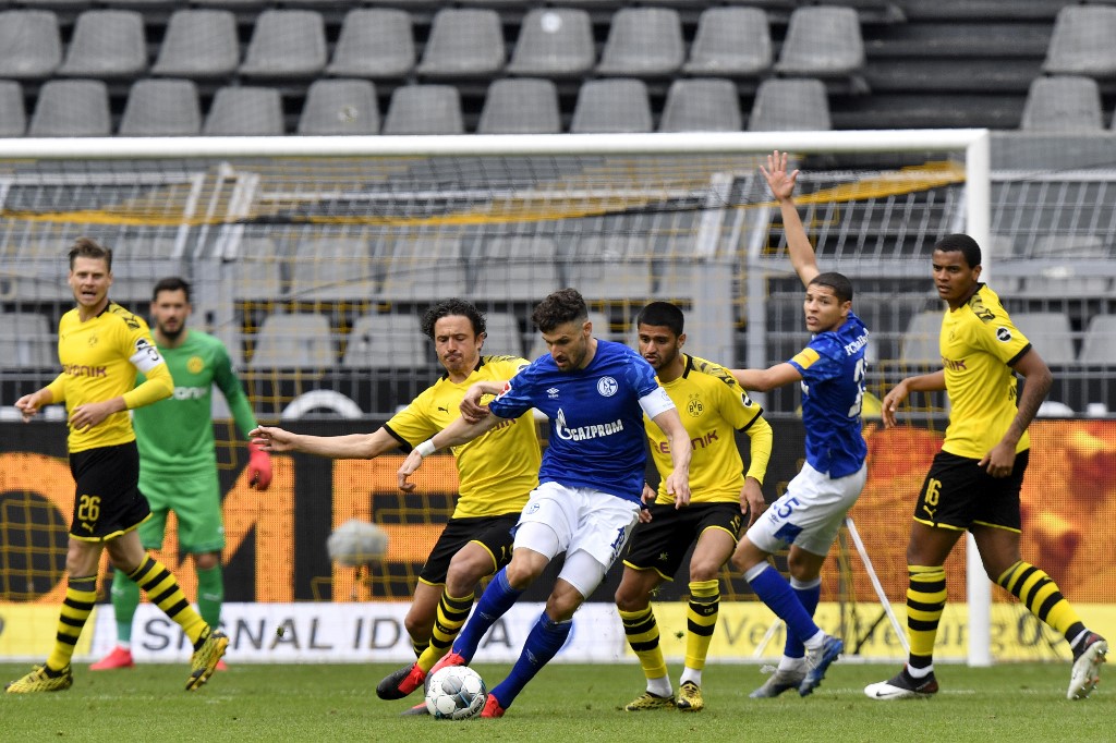 Dortmund's Danish midfielder Thomas Delaney, centre right, vies for the ball with Schalke's German midfielder Daniel Caligiuri during the German first division Bundesliga football match BVB Borussia Dortmund v Schalke 04 on May 16, 2020 in Dortmund. u00e2u20acu201d A