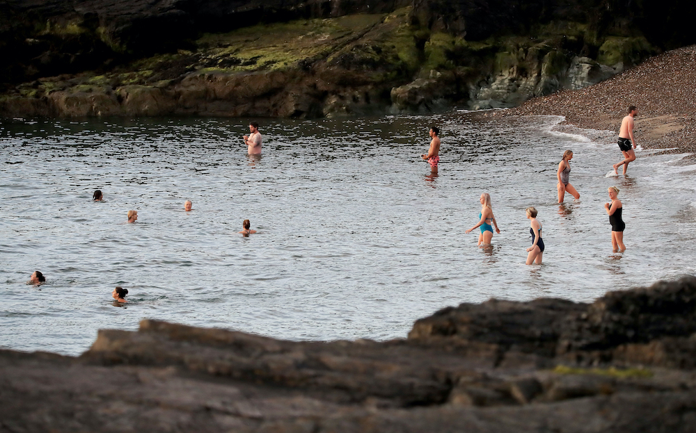 People swim in the early morning at Greystones beach in County Wicklow, as phase one of Ireland's five phase exit plan was triggered today. u00e2u20acu201d Reuters pic