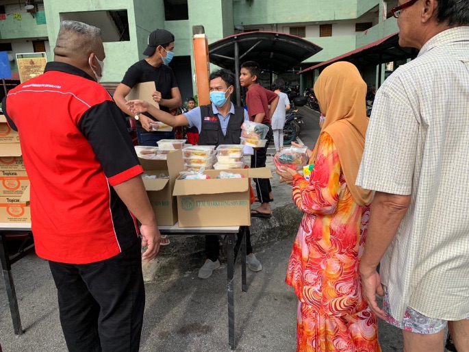 Food Bank Malaysia volunteers giving out the rolls to PPR communities. — Picture courtesy of IE Asia Sdn Bhd.