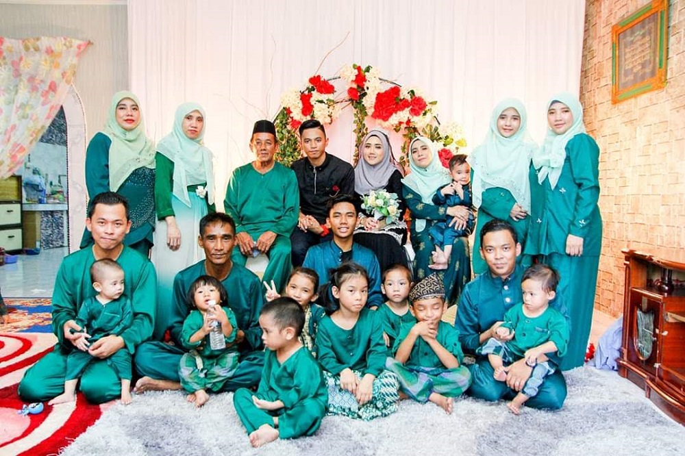 Siti Fatimah Awang (standing, far right) and her husband (seated front row, far right) with her extended family during Hari Raya Puasa in 2019. — Picture courtesy of Siti Fatimah Awang via TODAY