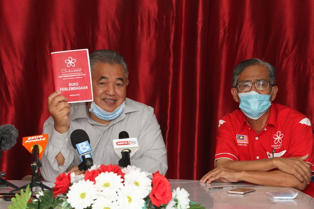 Johor Bersatu deputy chief Md Nasir Hashim (left) shows the partyu00e2u20acu2122s constitution book as Bersatu Johor Baru division chief Zais Mohd Akil looks on during the press conference in Johor Bari May 29, 2020. u00e2u20acu201d Picture by Ben Tan