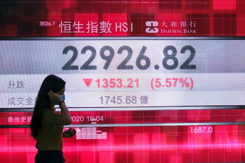 A woman walks past a panel displaying the afternoon trading Hang Seng Index, after Beijing's plans to impose national security legislation in Hong Kong, China May 22, 2020. u00e2u20acu201d Reuters pic