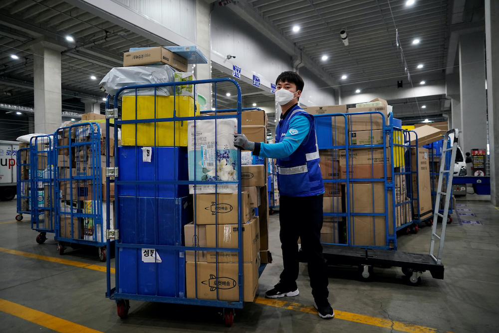 File picture of a delivery man for Coupang wearing a mask to prevent contracting the coronavirus, loading packages before leaving to deliver them in Incheon, South Korea, March 3, 2020. u00e2u20acu201d Reuters pic