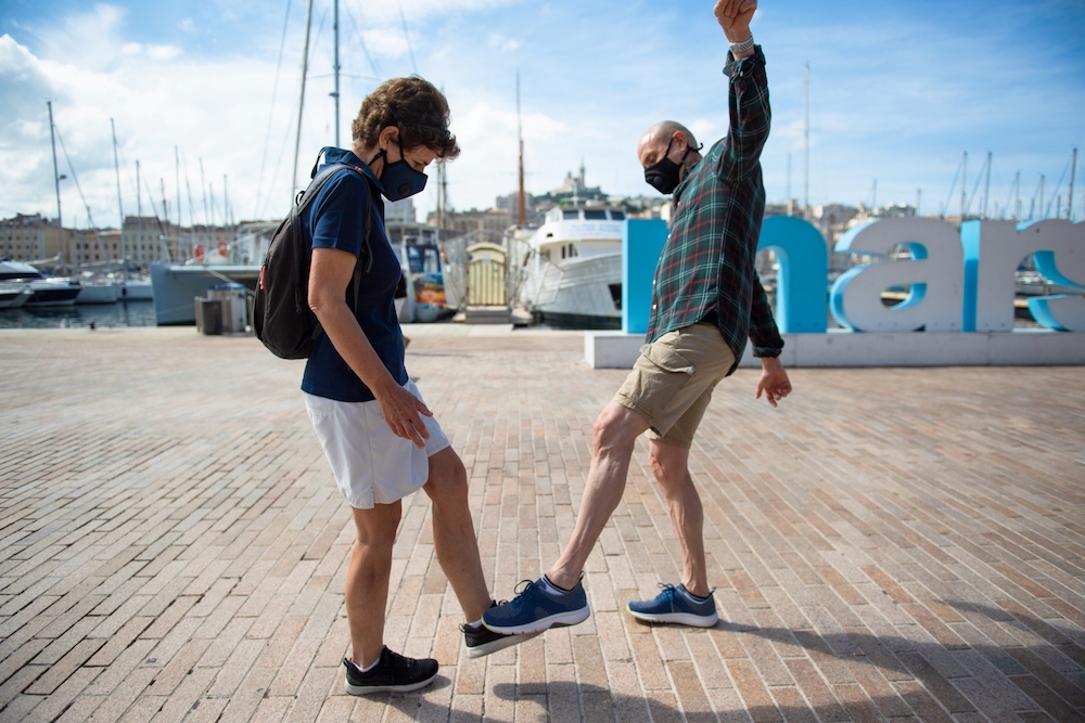 A man and a woman pose as they greet each other with their feet in the Vieux Port of Marseille southern France. u00e2u20acu201d AFP pic