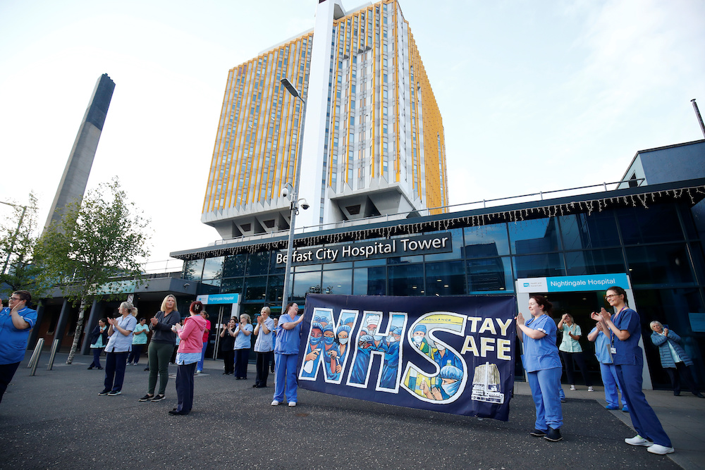 NHS workers with a banner react at the Nightingale Hospital during the Clap for our Carers campaign in support of the NHS, following the outbreak of the coronavirus disease in Belfast, Northern Ireland, May 7, 2020. u00e2u20acu201d Reuters picnn