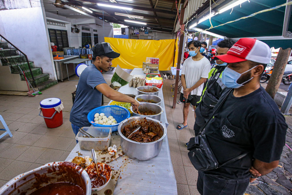 Customers wait to get their nasi lemak fix from Nasi Lemak Antarabangsa in Kampung Baru on May 4, 2020. — Picture by Hari Anggara 