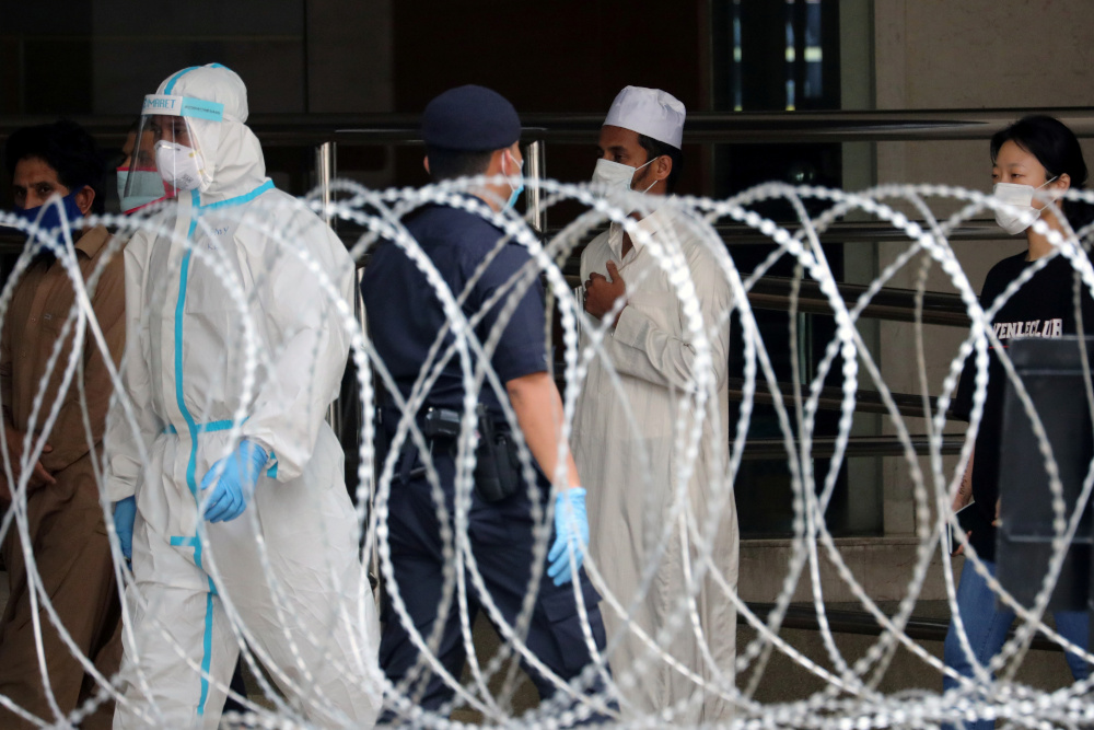 Illegal immigrants wait in line to be picked up by immigration officers outside an apartment under enhanced lockdown, during the movement control order in Kuala Lumpur, Malaysia, May 1, 2020. u00e2u20acu201d Reuters pic 