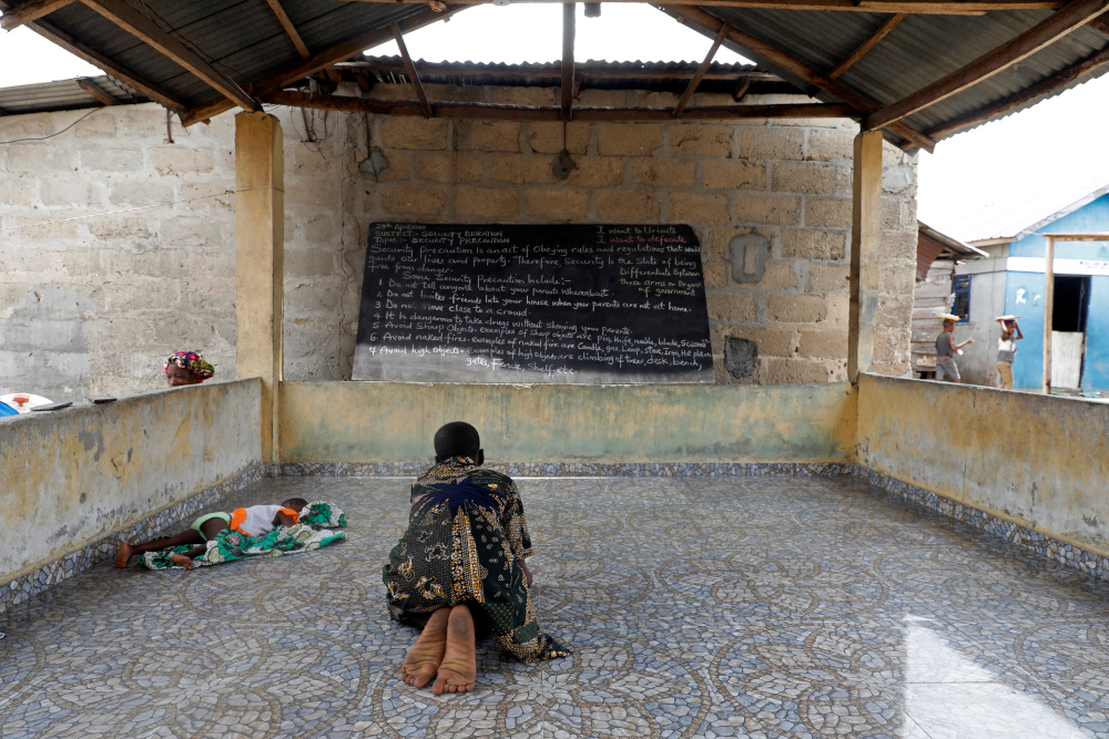 Tolu Alagba kneels to copy notes from a blackboard in a makeshift classroom arranged for children in Sagbo Kodji community during a lockdown to limit the spread of Covid-19 in Lagos, Nigeria April 25, 2020. u00e2u20acu201d Reuters pic 