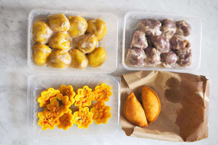 The 'kuih' is packed in plastic containers while the curry puffs arrives piping hot in a brown paper bag