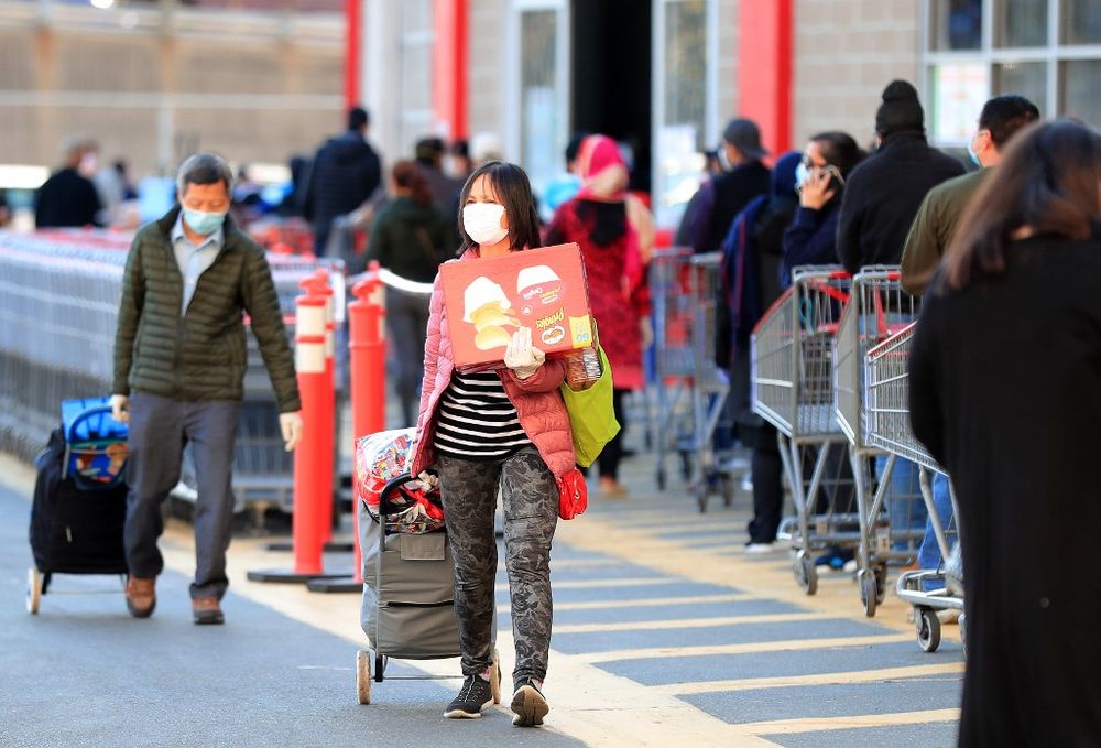 Customers exit with groceries as others wait in line to enter the Industry City Costco store on April 28, 2020 in the Brooklyn borough of New York City. u00e2u20acu201d AFP pic