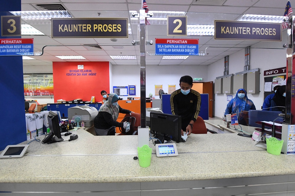 Staff are seen sanitising their work space at the National Registration Department office in Alor Setar April 21, 2020. u00e2u20acu201d Bernama pic