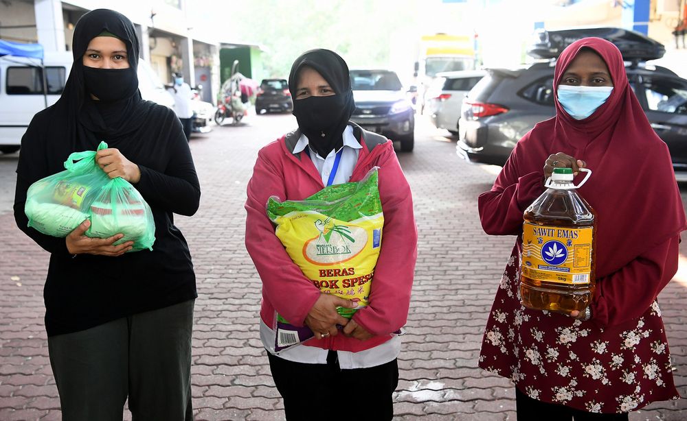 Musau00e2u20acu2122adah Covid-19 Fund recipients Mimie Abdul Maat (left), Zohrahashikin Shajauddin and Nur Suhaila Abddulah along with daily essentials presented by Minister in the Prime Ministeru00e2u20acu2122s Department Datuk Dr Zulkifli Mohamad Al- Bakri at the Asnaf Hari Ra
