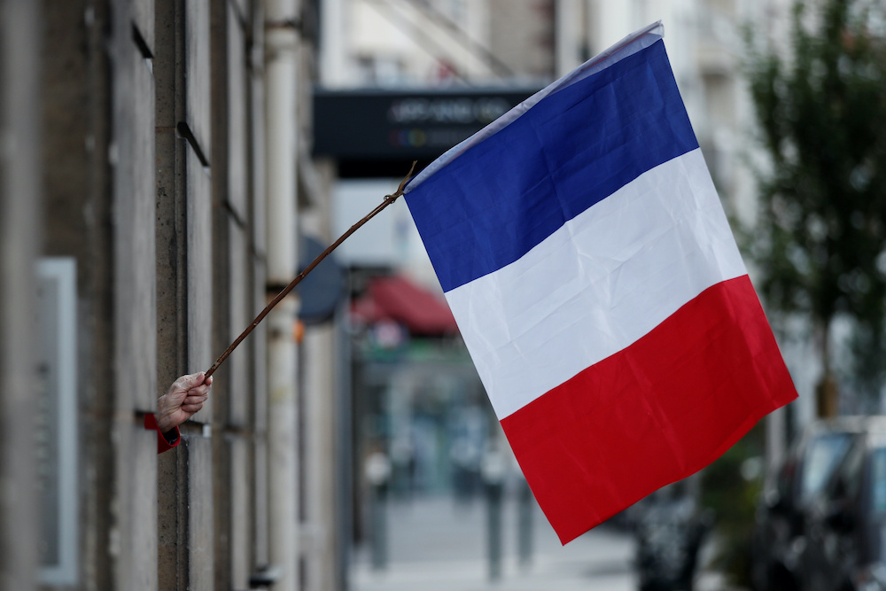 A woman waves a French flag from a window to support healthcare workers amid the coronavirus disease outbreak in Saint-Mande, near Paris, France May 5 2020. u00e2u20acu201d Reuters picnn