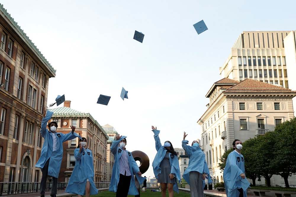 Graduating Masters students from the Columbia University Graduate School of Architecture, Planning and Preservation (GSAPP) throw their graduation caps in the air for a photo the day before their graduation ceremony in Manhattan May 15, 2020. u00e2u20acu2022 Reuters 