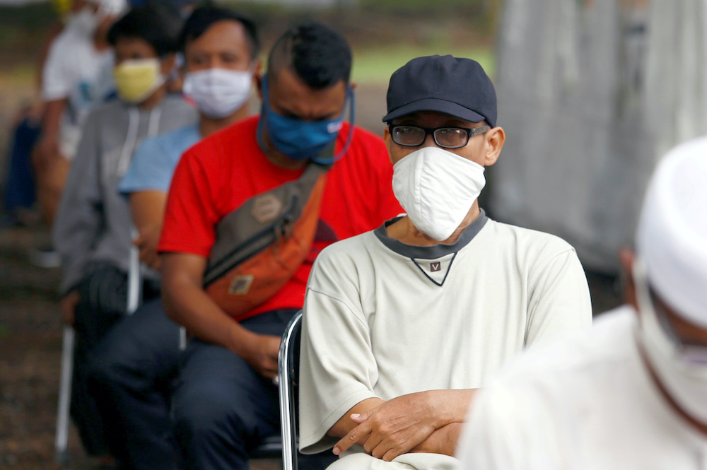 People wearing protective face masks and practising social distancing while receiving rice from an automated rice ATM distributor amid the coronavirus disease spread in Jakarta, Indonesia May 4, 2020. u00e2u20acu201d Reuters pic