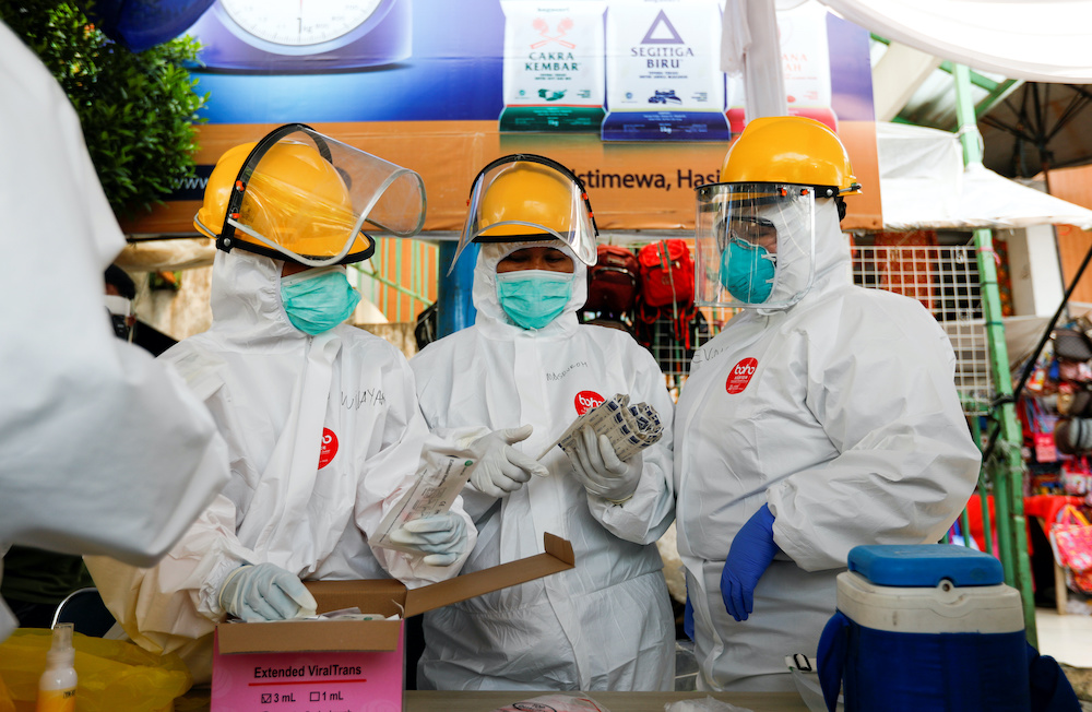 Healthcare workers prepare before taking swab samples from vendors amid the coronavirus disease outbreak, at a traditional market in Bogor, West Java province,Indonesia, May 8, 2020. u00e2u20acu201d Reuters picnn
