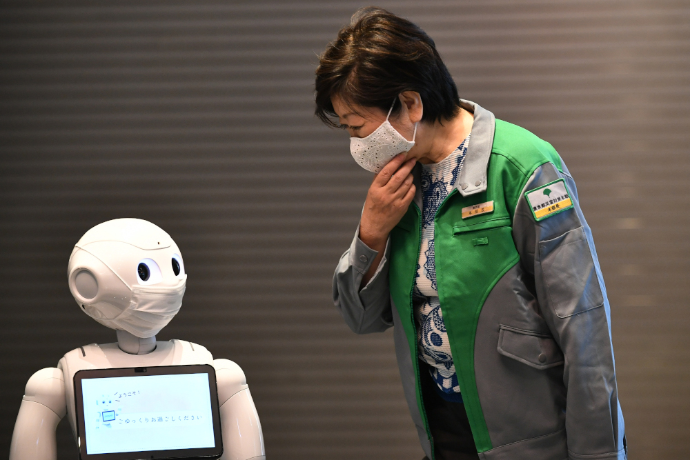 Tokyo governor Yuriko Koike looks at a greeting robot called ‘Pepper’ as she visits a hotel during an opening of a new medical lodging facilities to accommodate Covid-19 coronavirus patients with mild symptoms in Tokyo May 1, 2020. — AFP pic