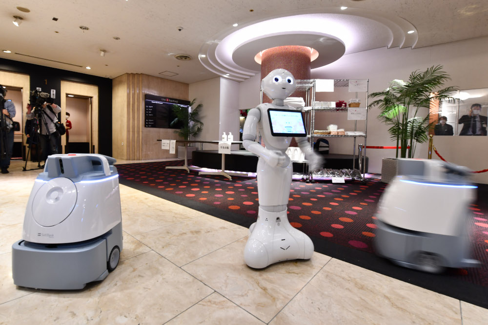 Japanese telecom giant Softbanku00e2u20acu2122s humanoid robot or greeting robot Pepper (centre) and cleaning robot Whiz at an entrance of a hotel which will accommodate patients suffering mild symptoms of Covid-19 in Tokyo April 30, 2020. u00e2u20acu201d AFP pic 