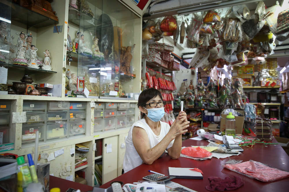 Sim Soom Hong, who owns a shop selling prayer items, has grown accustomed to her immigrant neighbours. ― Picture by Yusof Mat Isa
