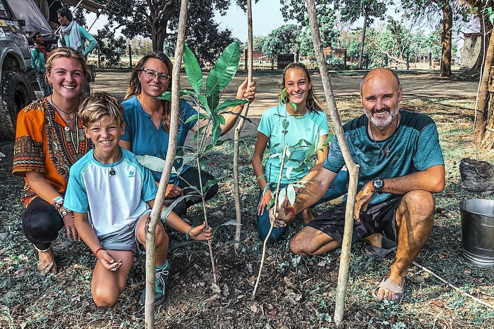 This handout picture taken on April 28, 2020 and received as a courtesy of Pallares family shows Patrice (right) and Virginie Pallares along with their children posing for a picture in front of the trees planted by villagers as a memento of their visit in